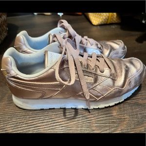 Pink rose gold shiny women’s reebok tennis shoes.
